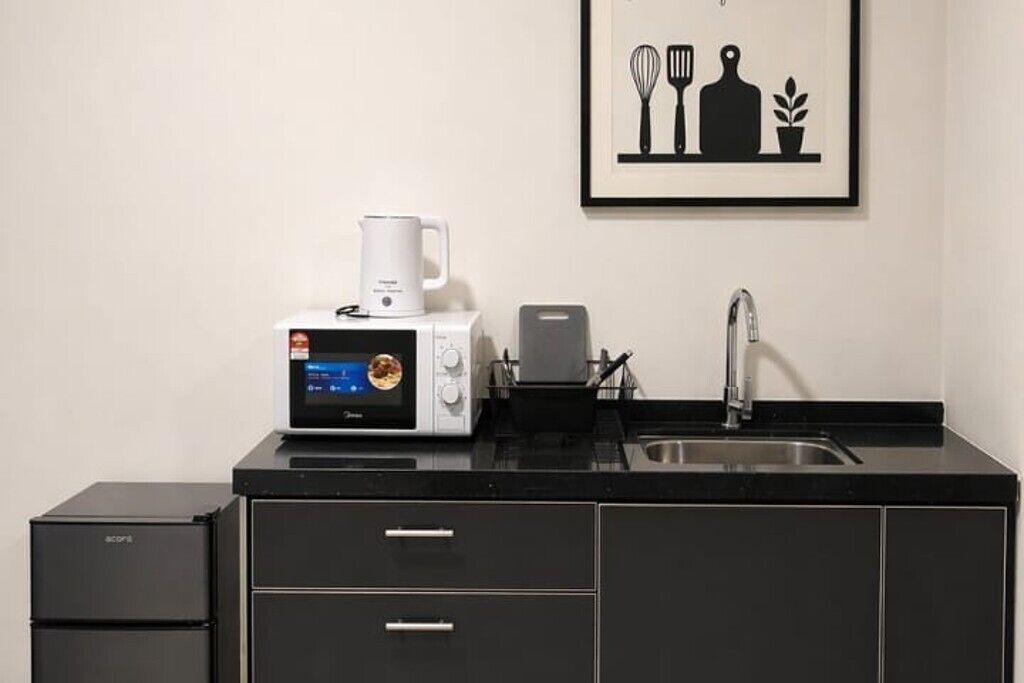 Una kitchenette equipada con microondas, tostadora y lavabo.