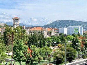 A historic building with a clock tower, surrounded by lush greenery and a clear sky. - Balcon Jean Jaures 3 City Center (Nice)