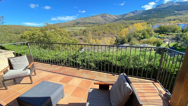 A terrace with a view of a mountainous landscape, a chair, and a small table. - El Secreto de las Eras - Charming rural house in Candelario, nature (Candelario)