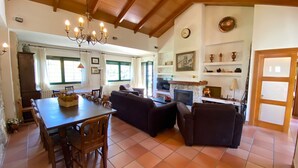 A spacious living area with a dining table, sofas, a television, and a fireplace. - El Secreto de las Eras - Charming rural house in Candelario, nature (Candelario)