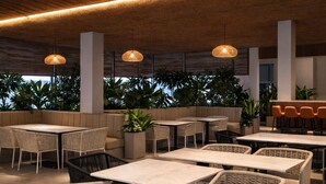 An outdoor seating area with wicker furniture and hanging lights.