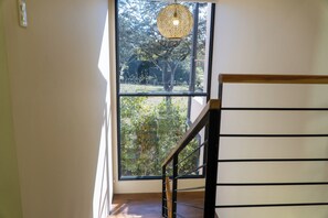 A staircase with a metal railing leading to a large window with a view of trees. - Luxury 6BR Villa - Private Pool - Walk to Beach - Tamarindo (Tamarindo)