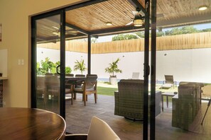 A covered outdoor patio with a dining area, wicker furniture, and potted plants. - Luxury 6BR Villa - Private Pool - Walk to Beach - Tamarindo (Tamarindo)