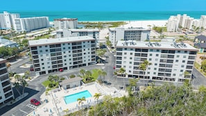 Ein Hochhotel mit mehreren Stockwerken, einem Pool auf dem Dach und Blick auf den Strand.