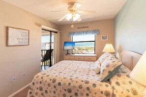 A bedroom with a bed, a desk with a computer, a window with a view, and a ceiling fan. - Fun In Sun On A Budget! 2B/2B Condo w/ Pool & Tennis! Walk to Beach! EC163 (Fort Myers Beach)