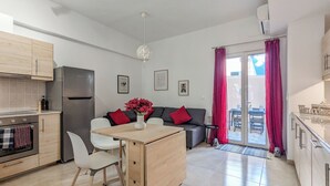 Una cocina moderna con refrigerador, horno y comedor con sillas y una mesa.