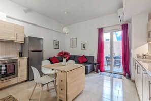 Eine moderne Küche mit Kühlschrank, Backofen und Essbereich mit Stühlen und Tisch.