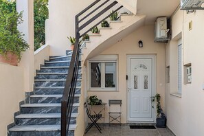Eine Treppe führt zu einer Tür, vor der sich ein Tisch und Stühle befinden.
