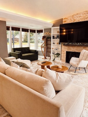 Una sala de estar con sofá, mesa de centro y chimenea.