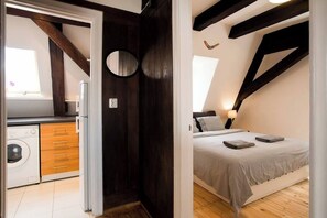 Ein Schlafzimmer mit einem Bett, einer Nachttischlampe und einem Fenster.