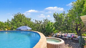 A swimming pool with a hot tub, surrounded by wooden decking and outdoor furniture. - Villa 'Casa Do Sol' in Tavira (Luz)