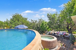 A swimming pool with a hot tub, surrounded by wooden decking and outdoor furniture. - Villa 'Casa Do Sol' in Tavira (Luz)