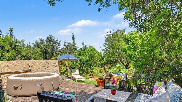 An outdoor patio with a hot tub, seating area, and potted plants. - Villa 'Casa Do Sol' in Tavira (Luz)