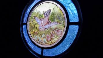 Una ventana de vitral con diseño de aves y flores.