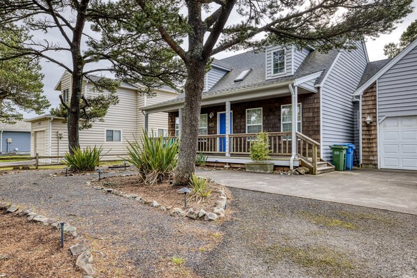 A residential house with a porch, a driveway, and a garage. - Undertow-Hot tub, block to beach, dog ok. 3 br. (Pacific City)