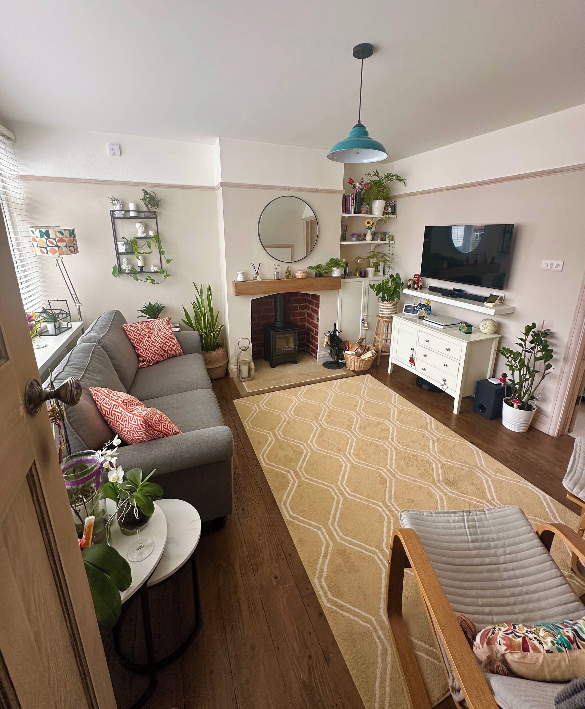 A living room with a sofa, a fireplace, a television, and various decorative items.
