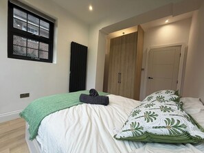 Een slaapkamer met een bed, een raam, een kast en een deur.