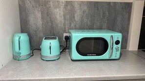 A kitchen with a toaster, kettle, and microwave on a countertop. - 1 Bed - Sleeps 2 - Free Parking (London)