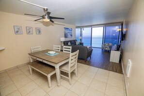 A dining area with a table and chairs, a ceiling fan, and artwork on the wall. - ONE BEDROOM CONDO 1107 (San Diego)