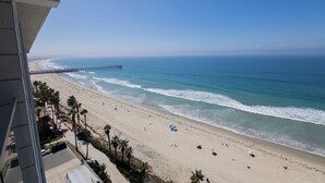 Ein Strand mit einer Mole, blauem Himmel und Blick auf das Meer.