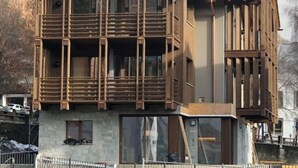 A modern two-story building with a wooden facade, large windows, and a balcony. - Bormio Apartments al pradais  giardino est  (Bormio)