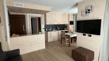 Bormio Apartments al pradais giardino est | Living area | 95-cm flat-screen TV with cable channels