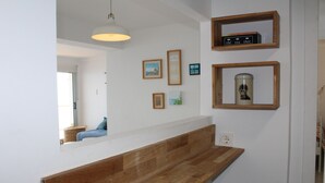 A modern kitchen with a wooden countertop, a hanging light fixture, and framed pictures on the wall. - Your Mediterranean dream home  - Costapinosmar (Salou)