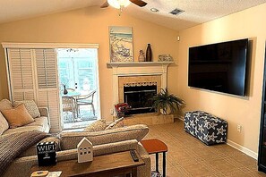A living room with a fireplace, a television, and a sofa. - 3-bedroom house in quaint Fernandina Beach with cool AC (Fernandina Beach)