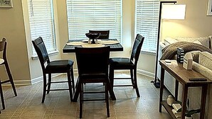 Un comedor con una mesa, sillas, un sofá y una lámpara.