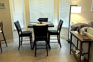 A dining area with a table and chairs, a sofa, and a lamp. - 3-bedroom house in quaint Fernandina Beach with cool AC (Fernandina Beach)