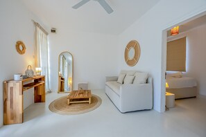 Ein modernes Wohnzimmer mit einer Couch, einem Couchtisch, einem Konsolentisch mit Lampen und einem großen Spiegel.