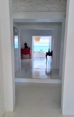 Ein Flur, der zu einem Balkon mit Meerblick führt.