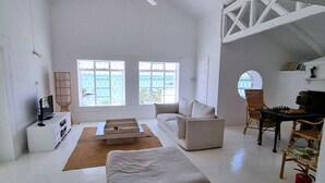 Ein geräumiges Wohnzimmer mit einer Couch, einem Couchtisch, einem Fernseher und einem Schachtisch.
