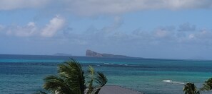 A coastal view with clear skies, ocean, and distant landmass.