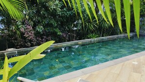 A swimming pool with clear water, surrounded by lush greenery and a tiled deck. - Sublime Pointe aux Canonniers (Pointe aux Canonniers)