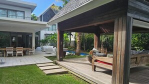 Ett modernt hus med en uteplats, utemöbler och en pool.
