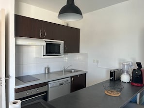 Eine moderne Küche mit Einbau-Mikrowelle, Geschirrspüler und Toaster.
