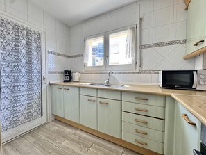 A kitchen with a window, a microwave, and a sink. - Spacious apartment, sea view - 4 guests (Roses)