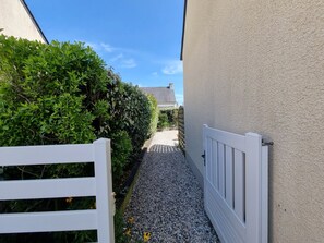 A narrow pathway leading to a building with a white gate and a hedge on one side. - House near the beach, pets welcome - 4 guests (Sarzeau)