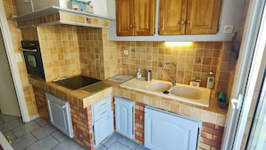 A compact kitchen with a stove, sink, and cabinets. - Lovely apartment with panoramic view - 6 guests (Canet-en-Roussillon)