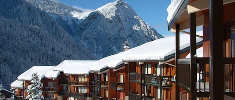 A snow-covered mountain resort with wooden buildings and balconies.