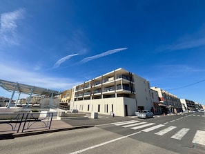A multi-story building with balconies, a pedestrian crossing, and a clear sky. - Bright apartment, beach view - 5 guests (Port-la-Nouvelle)