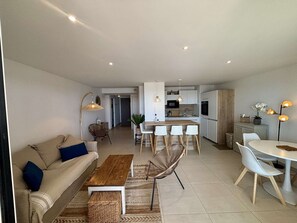 A modern apartment with a living room, dining area, and kitchen. - Bright apartment, beach view - 5 guests (Port-la-Nouvelle)