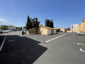 Ein Parkplatz mit Autos, ein kleines Gebäude und blauer Himmel.
