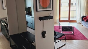 A modern living space with a sliding door leading to a balcony, a framed artwork on the wall, and a red rug on the floor. - Garbary Residence II Old Town (Poznań)