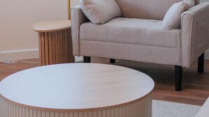 Olohuone, jossa on sohva, lamppu ja pyöreä sohvapöytä.