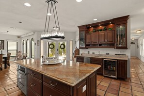 A spacious kitchen with a large island, wooden cabinets, and a built-in refrigerator. - Waterfront Home w Private Dock Hot Tub Fire Pit (Miramar Beach)