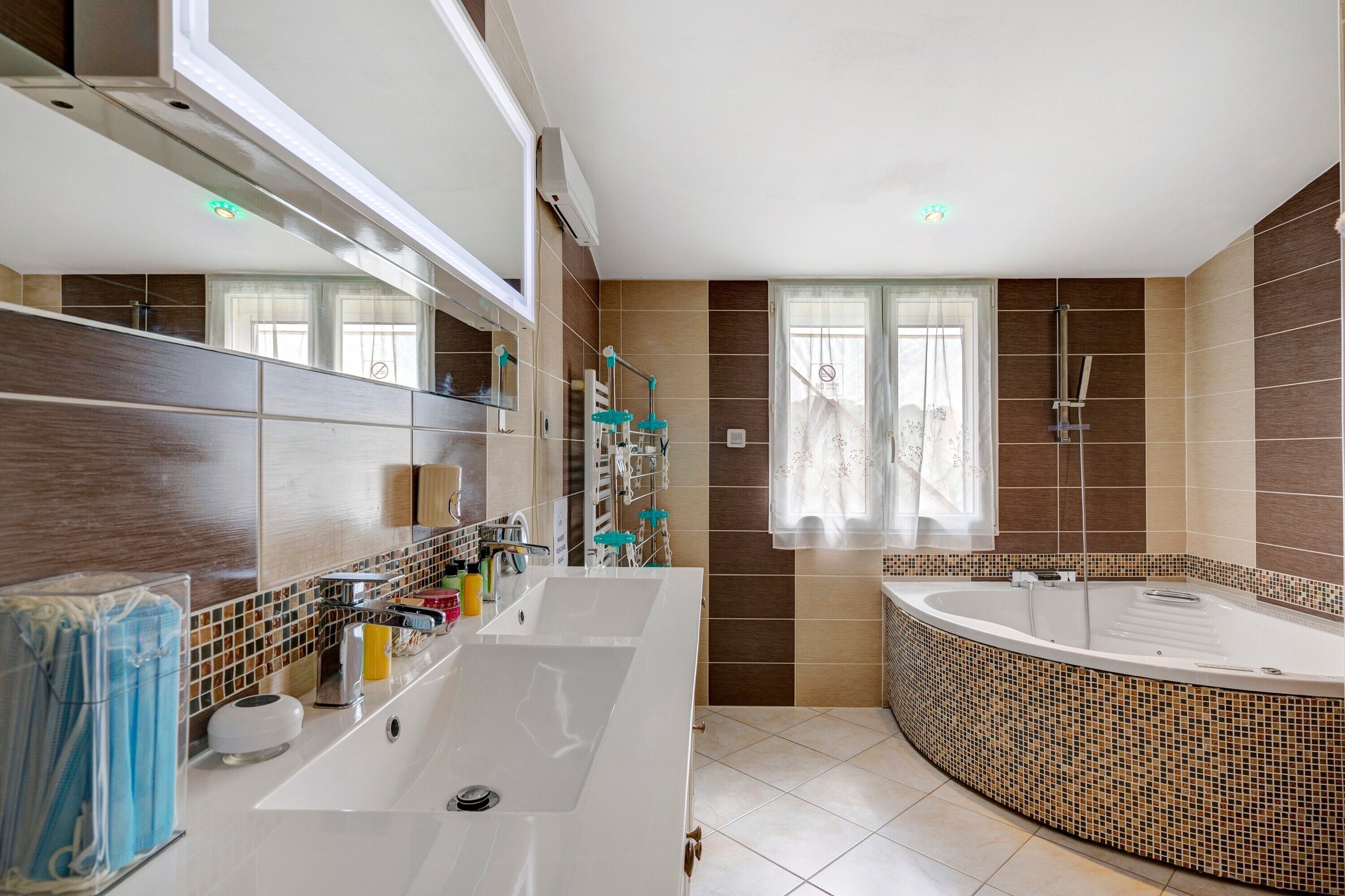 A modern bathroom with a large sink, mirror, and a freestanding bathtub.