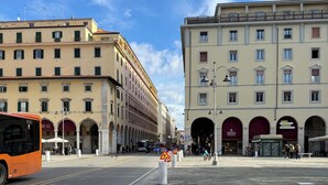 A street with buildings, a bus, and a pedestrian crossing.