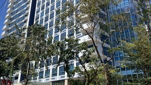 A high-rise building with a modern glass facade, multiple balconies, and a landscaped entrance area. - The City Escape: Stylish Condo Near Ayala Bloc & IT Park (Cebu City)